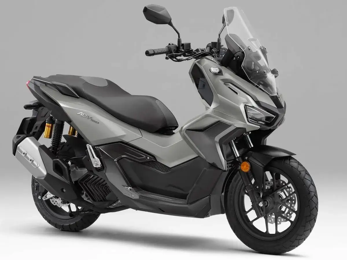 Scooter gris Honda ADV 160 con parabrisas alto y asiento doble. Lista para la aventura urbana.
