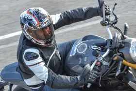 Motociclista con casco Suomy, con diseño llamativo, en una moto deportiva. Las opiniones sobre cascos Suomy son positivas.